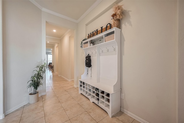 mudroom featuring crown molding, baseboards, and light tile patterned floors