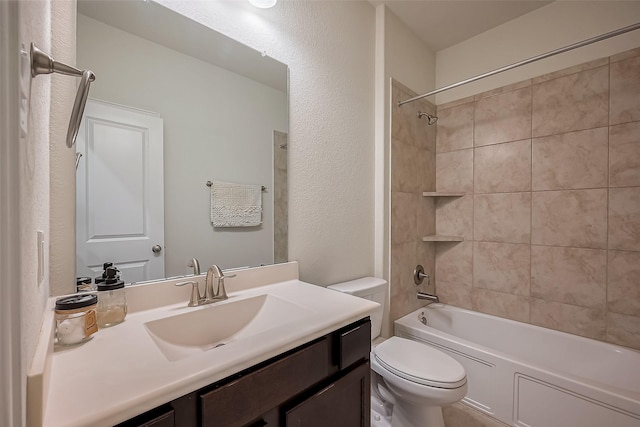 full bathroom featuring a textured wall, bathing tub / shower combination, toilet, and vanity