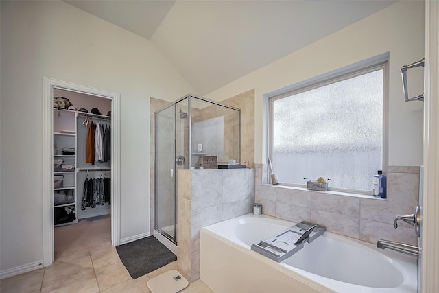 bathroom featuring vaulted ceiling, a spacious closet, plenty of natural light, and a shower stall