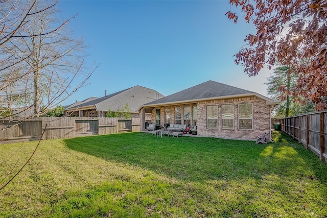 rear view of house featuring a yard, a fenced backyard, roof with shingles, and brick siding