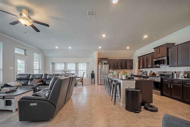 living room with light tile patterned floors, visible vents, lofted ceiling, crown molding, and recessed lighting