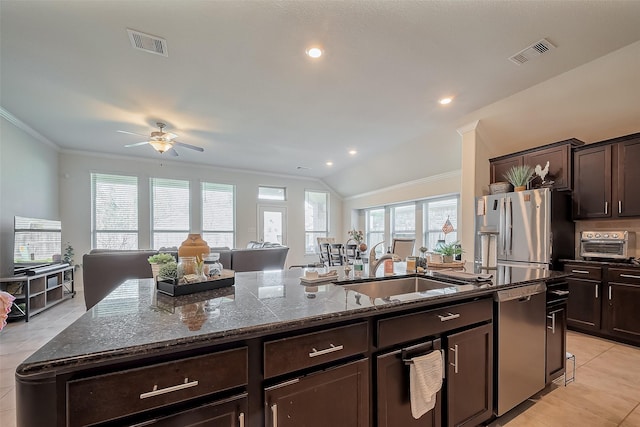 kitchen featuring appliances with stainless steel finishes, a kitchen island with sink, visible vents, and a sink