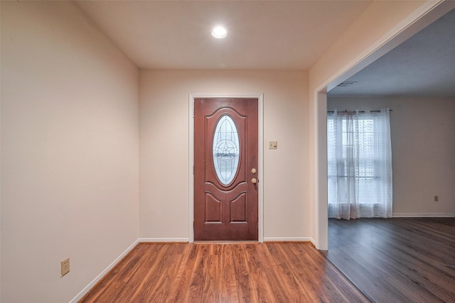 entrance foyer featuring a wealth of natural light, baseboards, and wood finished floors