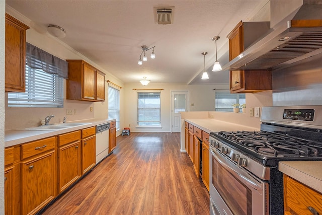 kitchen with a sink, visible vents, dishwasher, wall chimney exhaust hood, and gas range