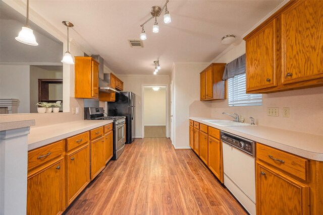 kitchen with gas range, brown cabinetry, a sink, and dishwasher