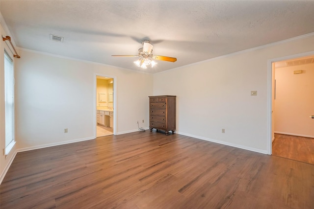 interior space with baseboards, visible vents, wood finished floors, and ornamental molding