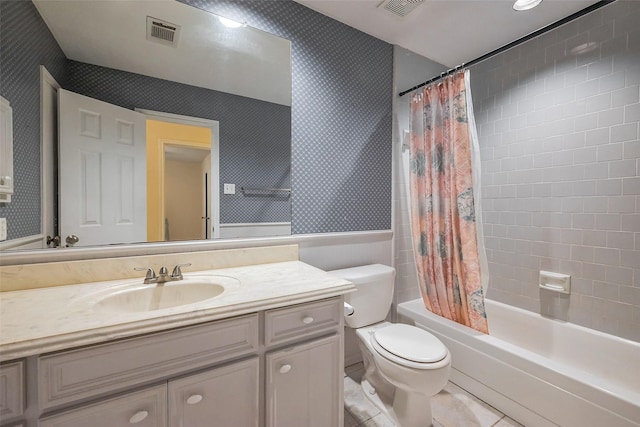 bathroom featuring toilet, a wainscoted wall, visible vents, and wallpapered walls