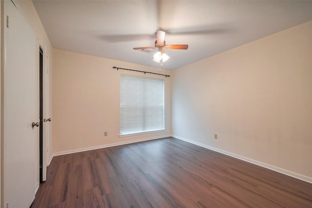 unfurnished room featuring dark wood-style floors, baseboards, and a ceiling fan