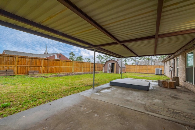 view of patio with an outbuilding, central AC, a fenced backyard, and a shed