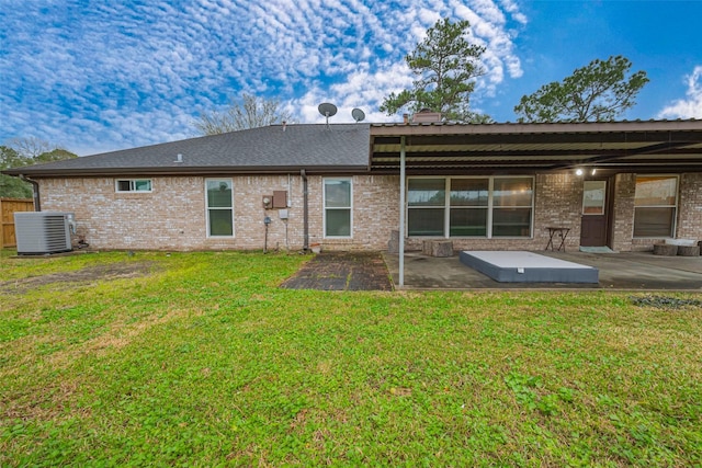 back of property with brick siding, a patio, cooling unit, and a yard