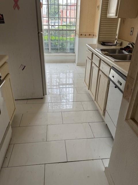 kitchen with white appliances, light tile patterned flooring, light countertops, and a sink