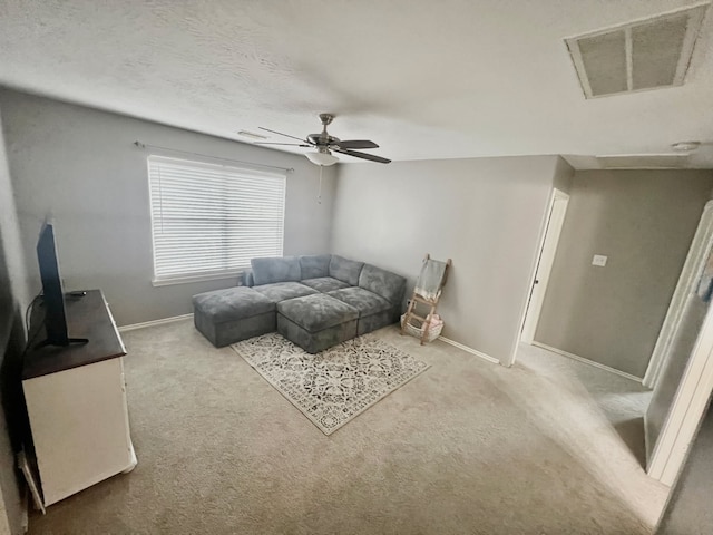 carpeted living room featuring a textured ceiling, a ceiling fan, visible vents, and baseboards