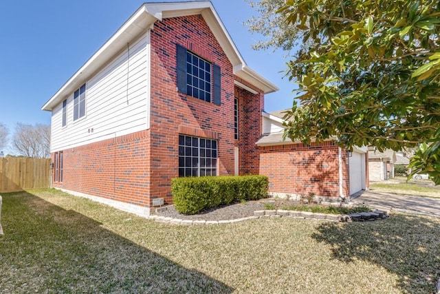 view of side of property featuring a garage, brick siding, a lawn, and fence