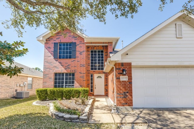 traditional-style house featuring a front lawn, brick siding, central AC, and an attached garage