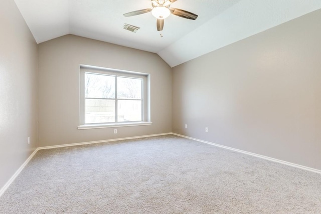 spare room featuring lofted ceiling, visible vents, ceiling fan, and baseboards