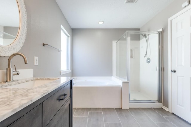 bathroom with tile patterned flooring, visible vents, vanity, a shower stall, and a bath