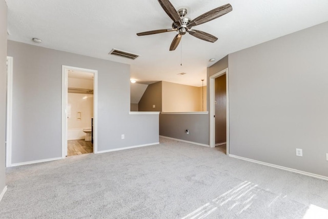 carpeted spare room with a ceiling fan, visible vents, and baseboards