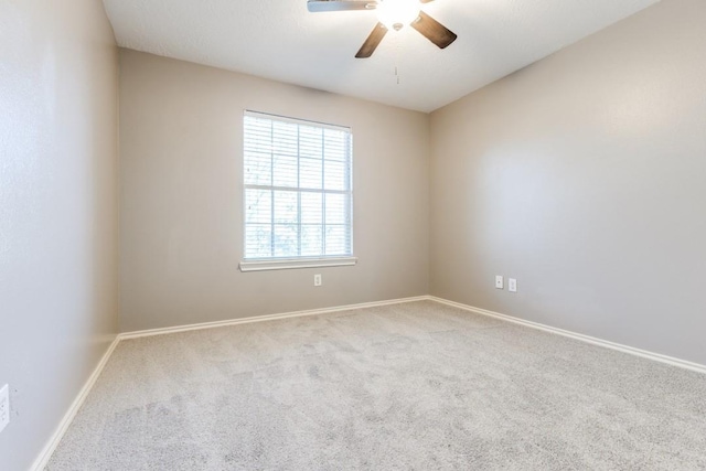 carpeted empty room with ceiling fan and baseboards