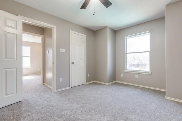 unfurnished bedroom featuring a ceiling fan, carpet, and baseboards