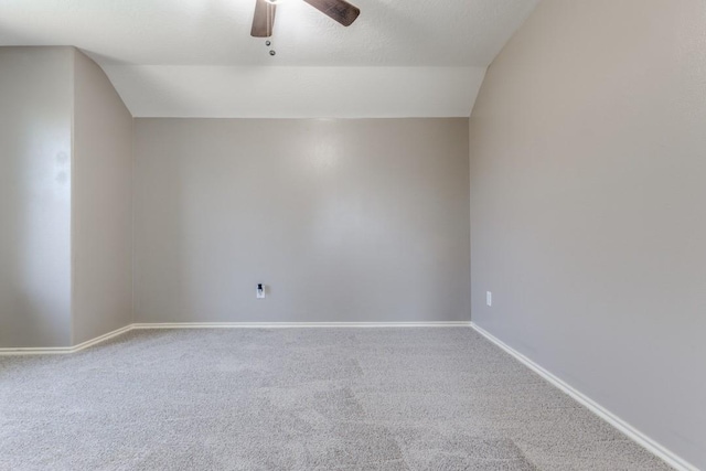 spare room with carpet floors, baseboards, vaulted ceiling, and a ceiling fan