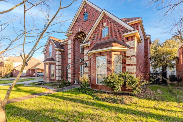 view of front of property with a front yard, fence, and brick siding