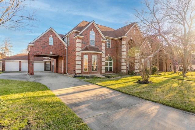 view of front of house with a front yard, concrete driveway, brick siding, and roof with shingles