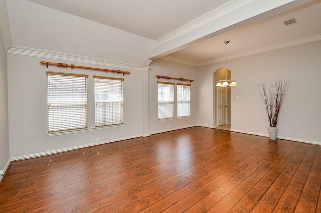 unfurnished room with a notable chandelier, visible vents, ornamental molding, baseboards, and hardwood / wood-style flooring