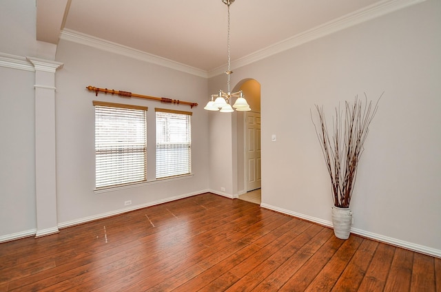 spare room featuring wood-type flooring, a chandelier, baseboards, and ornamental molding