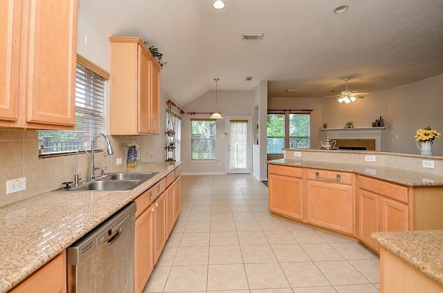 kitchen with dishwasher, light brown cabinetry, and a sink