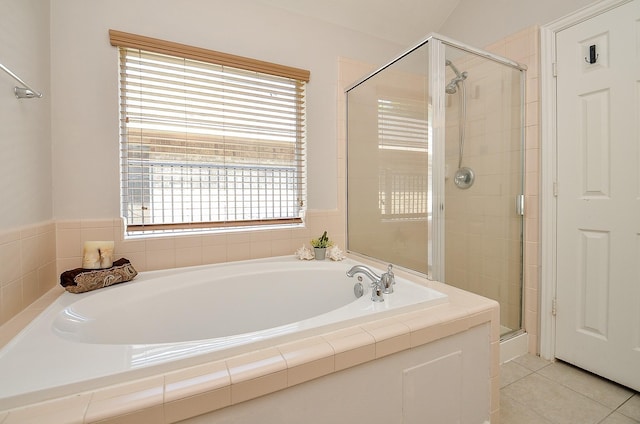 full bathroom with a shower stall, a bath, and tile patterned floors