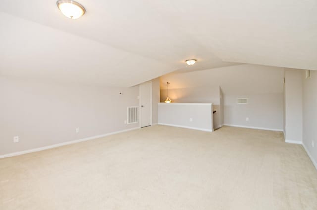 bonus room featuring visible vents, vaulted ceiling, light carpet, and baseboards