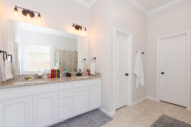 full bathroom featuring double vanity, a shower stall, ornamental molding, and a sink