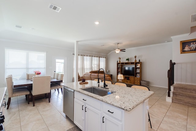 kitchen featuring crown molding, a center island with sink, visible vents, a sink, and dishwasher