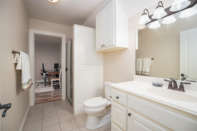 full bathroom featuring toilet, a notable chandelier, vanity, tile patterned floors, and a stall shower