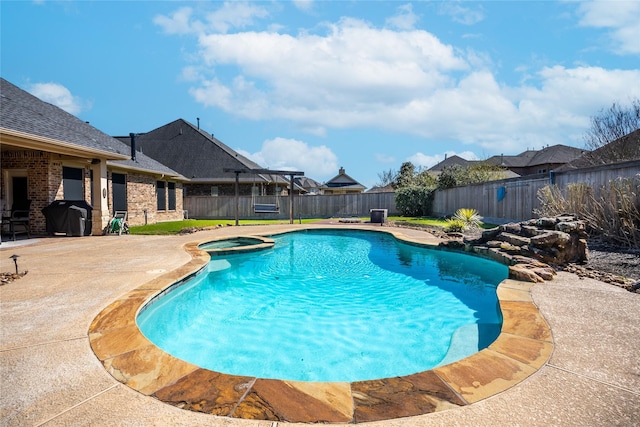 view of pool featuring a pool with connected hot tub, a fenced backyard, a grill, and a patio