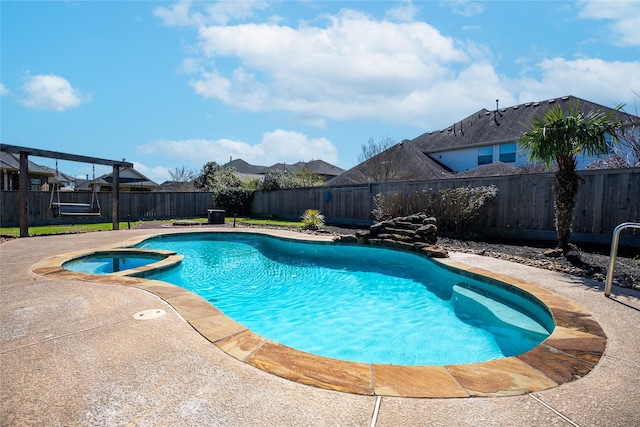 view of pool featuring a patio area, a fenced backyard, and a pool with connected hot tub