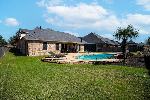 view of swimming pool with a lawn, a patio area, a fenced backyard, and a fenced in pool