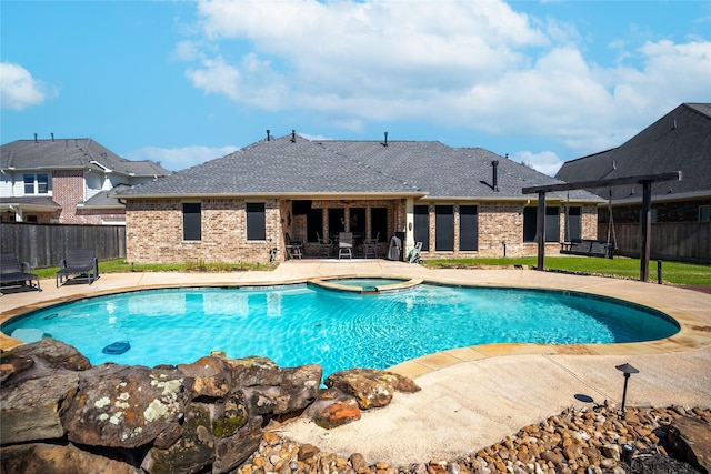 view of swimming pool featuring a patio, fence, and a pool with connected hot tub