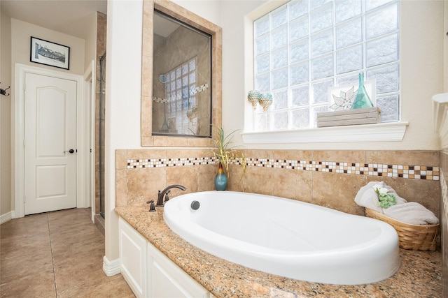 bathroom featuring tile patterned floors, a shower stall, and a bath