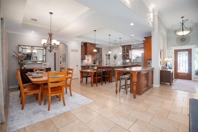 dining area featuring a raised ceiling, visible vents, and a healthy amount of sunlight