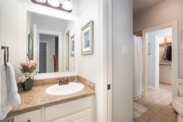 bathroom featuring tile patterned flooring, curtained shower, vanity, and toilet