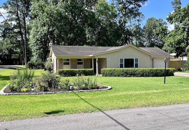 ranch-style house with a front lawn, an attached garage, and brick siding