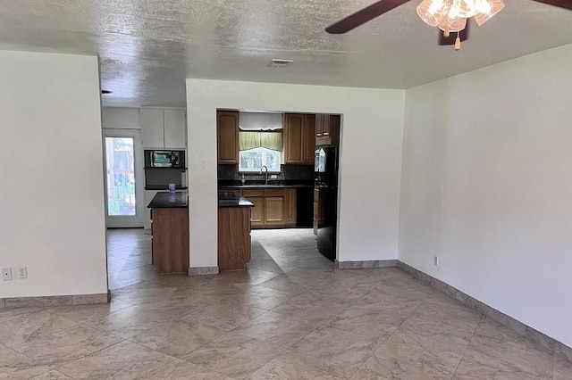 kitchen featuring dark countertops, visible vents, backsplash, a sink, and black appliances