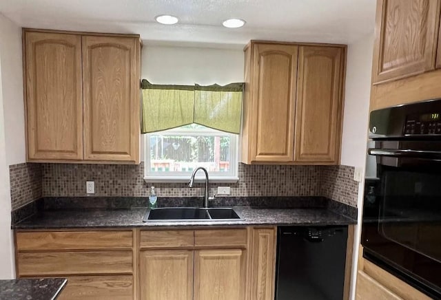 kitchen with a sink, light brown cabinetry, black appliances, tasteful backsplash, and dark countertops