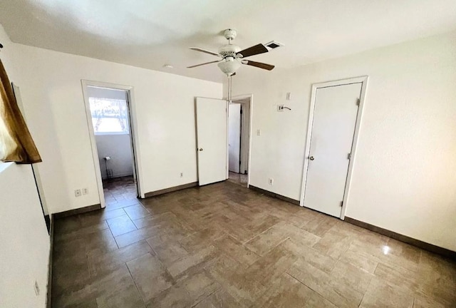 unfurnished bedroom featuring baseboards, visible vents, a ceiling fan, and ensuite bathroom