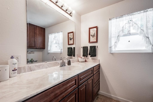 bathroom with tile patterned flooring, vanity, and baseboards