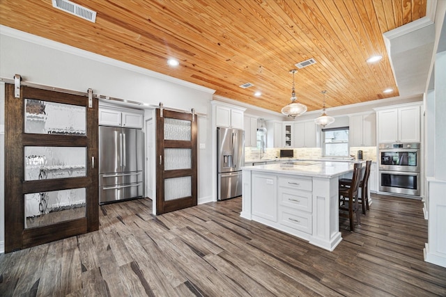 kitchen featuring a barn door, stainless steel appliances, wood ceiling, visible vents, and ornamental molding