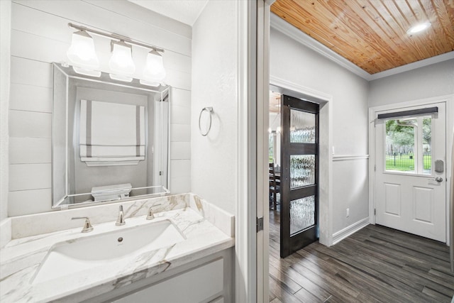 bathroom featuring toilet, ornamental molding, wood ceiling, vanity, and wood finished floors