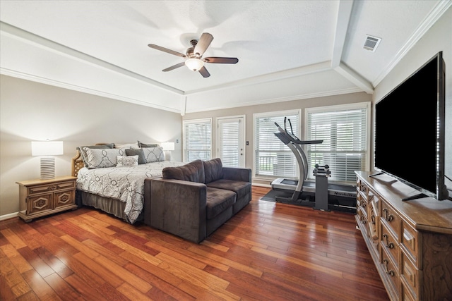 bedroom featuring hardwood / wood-style floors, multiple windows, visible vents, and crown molding