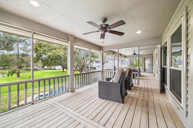 sunroom / solarium featuring a ceiling fan